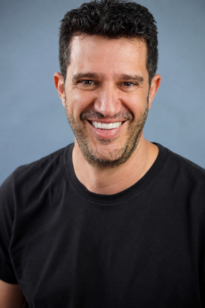 Antonio Escudero actor - retrato profesional en headshot sonriente con fondo azul