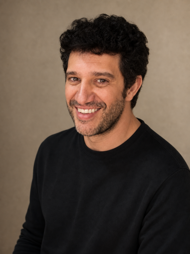 Antonio Escudero actor - retrato profesional sonriente con fondo de estudio cálido